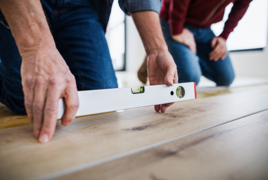 person measuring evenness of luxury vinyl tile 